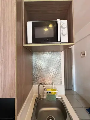 a microwave above a sink in a small kitchen at PaulBert's Cabins II in Sampong