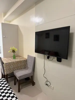 a flat screen tv hanging on a wall in a room at Sea Residences Staycation Near MOA Pasay City by Rose in Manila