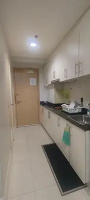 a kitchen with white cabinets and a sink and a door at Sea Residences Staycation Near MOA Pasay City by Rose in Manila