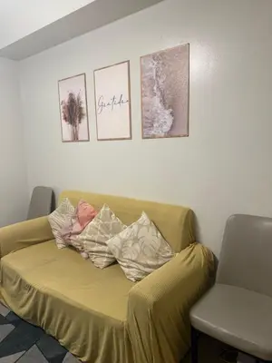 a couch in a room with pictures on the wall at Sea Residences Staycation Near MOA Pasay City by Rose in Manila