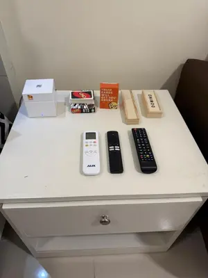 a white table with three remote controls on it at Sea Residences Staycation Near MOA Pasay City by Rose in Manila