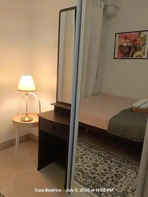 a bedroom with a mirror and a bed and a lamp at Cozy 19 at Shore 2 Residences in Manila