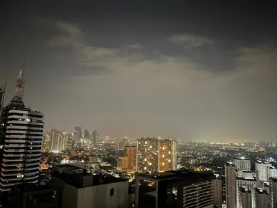 a view of a city skyline at night at FAME Residences - The 37th Suite in Manila