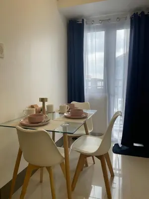 a dining room with a glass table and chairs at FAME Residences - The 37th Suite in Manila