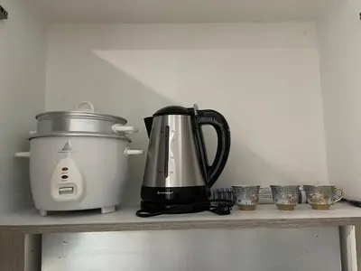 a coffee maker and a toaster sitting on a shelf at FAME Residences - The 37th Suite in Manila