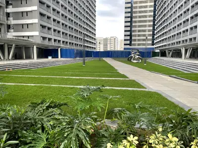 a grassy area in a city with tall buildings at FAME Residences - The 37th Suite in Manila