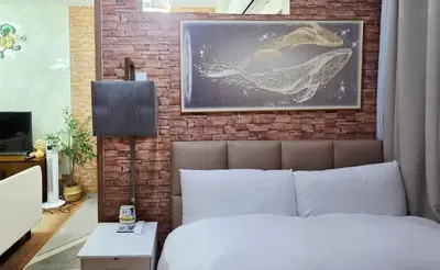 a bedroom with a brick wall with a bed and a picture at Luxe Vintage with Best View MallofAsia Airport in Manila
