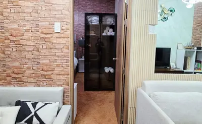 a living room with a brick wall and a black door at Luxe Vintage with Best View MallofAsia Airport in Manila