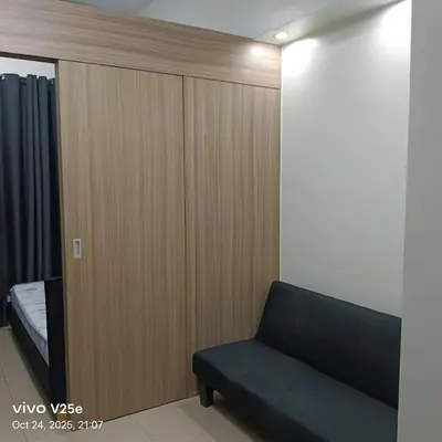 a room with a couch and a wooden wall at shore 2 residences admin in Manila