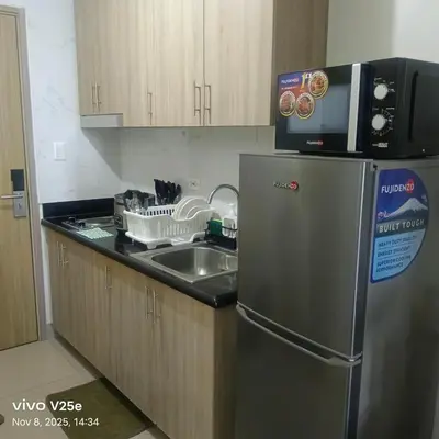 a kitchen with a stainless steel refrigerator and a sink at shore 2 residences admin in Manila