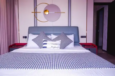 a bed with white sheets and pillows on it at Luxury Condo at Bayshore Residential Phase 2 beside OKADA & near MOA in Manila