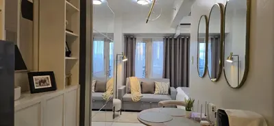 a living room with a couch and a table at Homey Roxas Blvd Condo Pool Parking WiFi in Manila