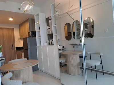 a kitchen with two tables and chairs in a room at Homey Roxas Blvd Condo Pool Parking WiFi in Manila