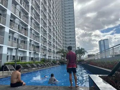 a group of people in a swimming pool in a building at Homey Roxas Blvd Condo Pool Parking WiFi in Manila