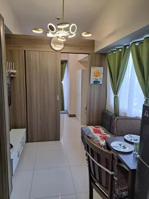 a living room with a table and a dining room at Gavinne Place Coast Residences in Manila