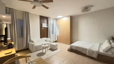 a bedroom with a bed and a couch and a chair at Resort Condo in Trece Martires Cavite in Trece Martires