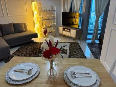 a living room with two plates and a vase of flowers on a table at BGC Premium 1BR with Balcony fast 600 mbps Fibre in Manila