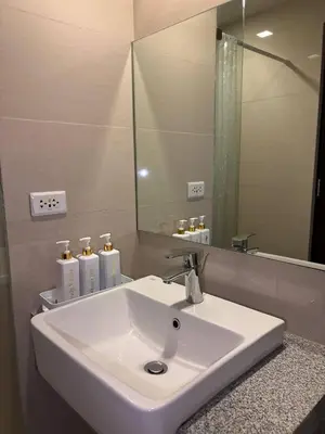 a white sink in a bathroom with a mirror at BGC Premium 1BR with Balcony fast 600 mbps Fibre in Manila