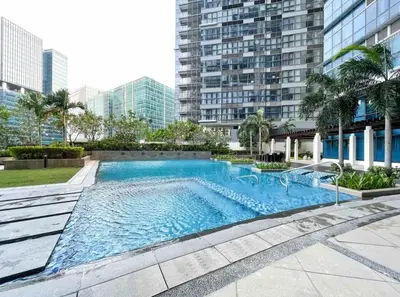 a large swimming pool in the middle of a building at BGC Premium 1BR with Balcony fast 600 mbps Fibre in Manila