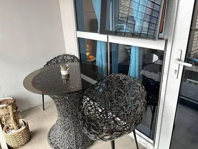 a black table and two chairs and a table and a window at BGC Premium 1BR with Balcony fast 600 mbps Fibre in Manila