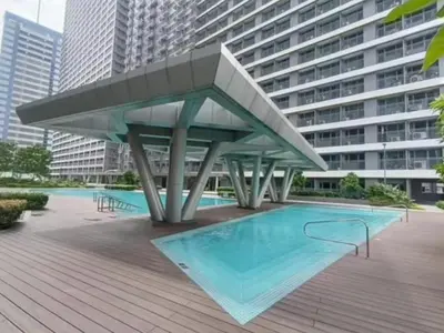 a swimming pool with a large building in the background at Condo unit for rent in Manila