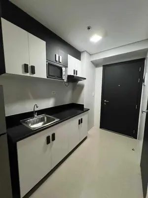 a kitchen with a sink and a microwave at Staycation in Oasis in Manila