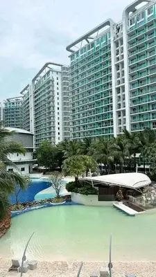 a large swimming pool in front of a large building at Staycation in Oasis in Manila