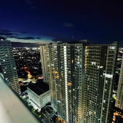 a view of a city at night with tall buildings at Staycation in Oasis in Manila