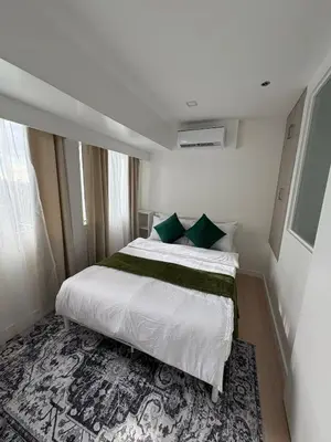 a bedroom with a large white bed with green pillows at 3BR golf view in fort victoria BGC in Manila