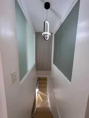 a hallway with a staircase and a light fixture at 3BR golf view in fort victoria BGC in Manila