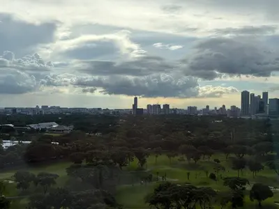 a view of a park with a city in the background at 3BR golf view in fort victoria BGC in Manila