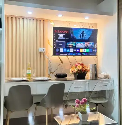 a desk with two chairs and a television on the wall at JB Urban Nest at SMDC Fame Residences in Manila