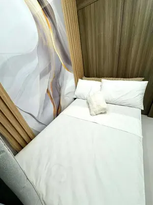 a small bed with white sheets and pillows at JB Urban Nest at SMDC Fame Residences in Manila