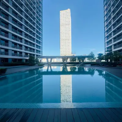 a swimming pool in the middle of two tall buildings at JB Urban Nest at SMDC Fame Residences in Manila