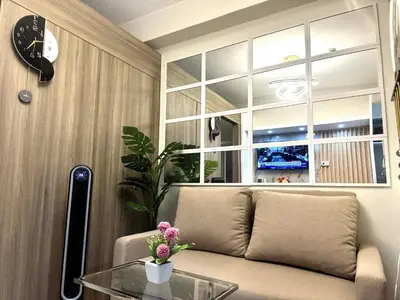 a living room with a couch and a glass table at JB Urban Nest at SMDC Fame Residences in Manila