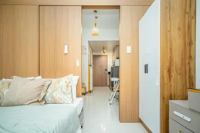 a bedroom with a bed and a hallway at Boho Makati Condo w/ Wi-Fi + Workspace | Red in Manila