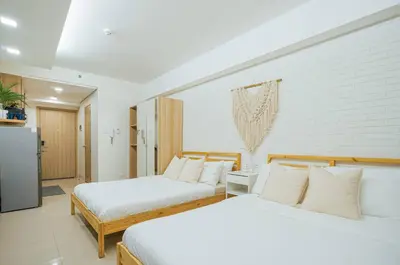 two beds in a hotel room with white sheets at Relaxing Hotel Apartment Stay : Near MOA & Airport in Manila