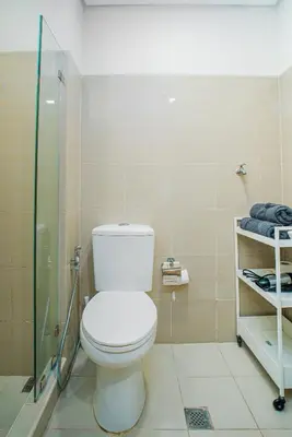 a bathroom with a toilet and a glass shower at Relaxing Hotel Apartment Stay : Near MOA & Airport in Manila