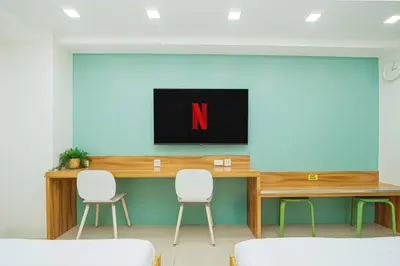 a conference room with a tv and two chairs at Relaxing Hotel Apartment Stay : Near MOA & Airport in Manila