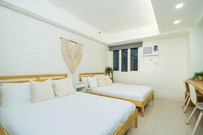 two beds in a room with white walls at Relaxing Hotel Apartment Stay : Near MOA & Airport in Manila
