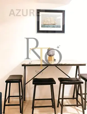 a dining room table with four stools at it at RTO Staycation in Manila