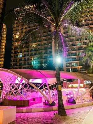 a palm tree in front of a building with purple lights at RTO Staycation in Manila
