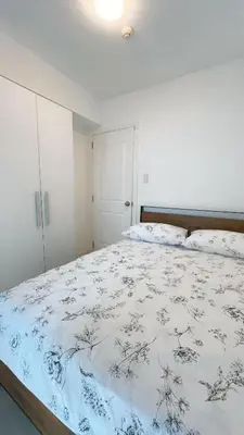 a bedroom with a bed with a blue and white comforter at RTO Staycation in Manila