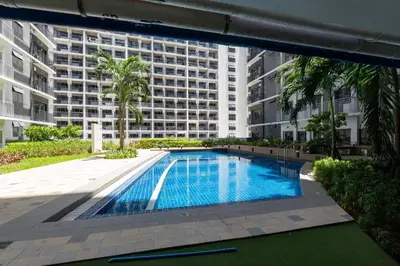 a swimming pool in front of a large building at Modern Industrial 1 BR | Condo | MOA Shore 3 NAIA in Manila