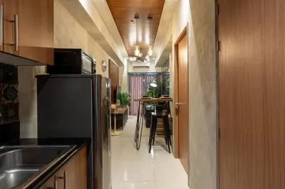 a kitchen with a black refrigerator and a dining room at Modern Industrial 1 BR | Condo | MOA Shore 3 NAIA in Manila