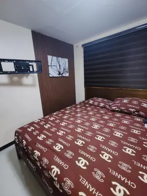 a bedroom with a bed with a red comforter at David home in Manila