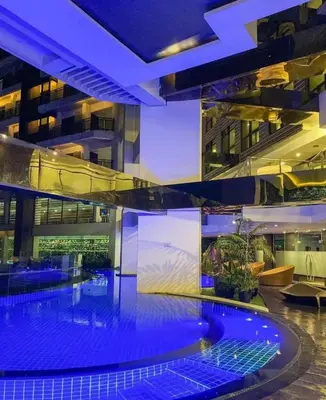 a large building with a swimming pool at night at Elegant Stylish 1 Bedroom Balcony City and Manila Bay view FREE Sauna Pool GYM Makati in Manila