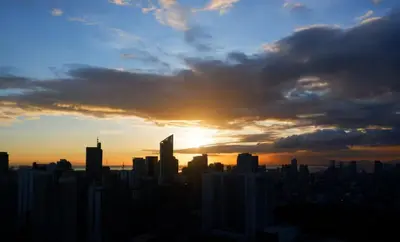 a city skyline with the sun setting in the sky at Elegant Stylish 1 Bedroom Balcony City and Manila Bay view FREE Sauna Pool GYM Makati in Manila