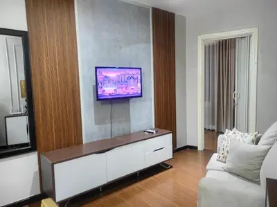 a living room with a couch and a tv on a wall at Elegant Stylish 1 Bedroom Balcony City and Manila Bay view FREE Sauna Pool GYM Makati in Manila