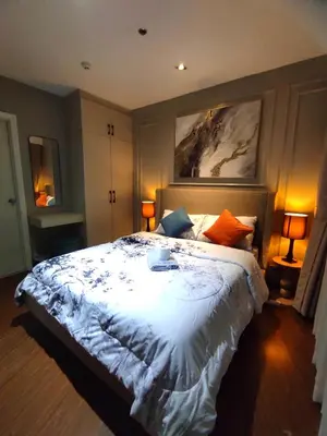 a bedroom with a large bed with a white comforter at Elegant Stylish 1 Bedroom Balcony City and Manila Bay view FREE Sauna Pool GYM Makati in Manila